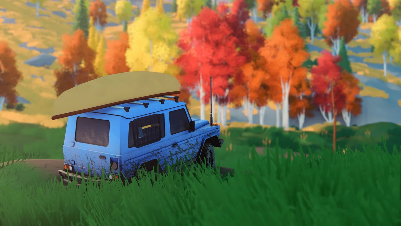 A blue camper with a canoe on its roof stands in grass beside orange and yellow trees.